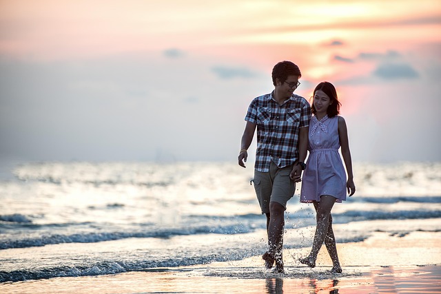 晴れた日にサングラスをかけて笑顔で歩く男女
