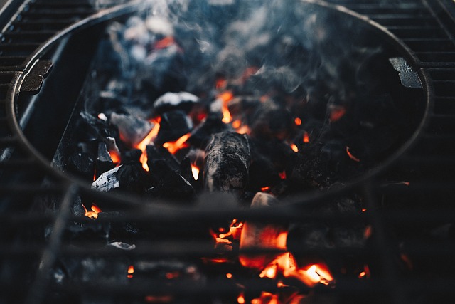 家族や友人とBBQを楽しむ人々、中央には様々な食材が並べられたBBQコンロ