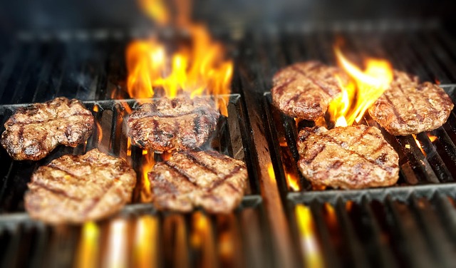 炭火で肉や野菜が焼かれているBBQコンロのクローズアップ