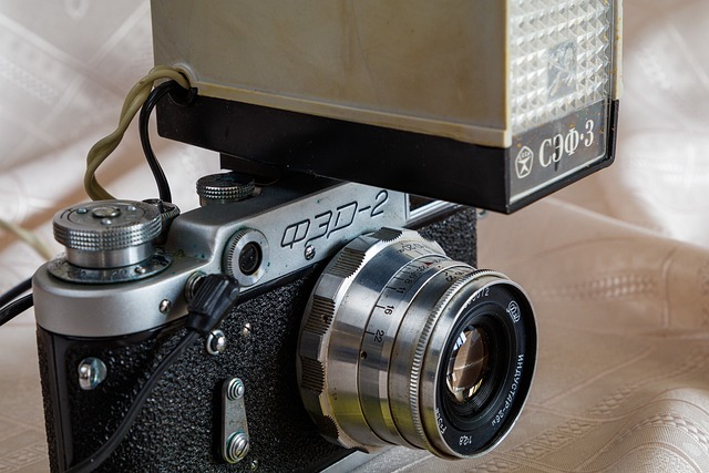 カメラにフラッシュを装着し、設定を調整する手元