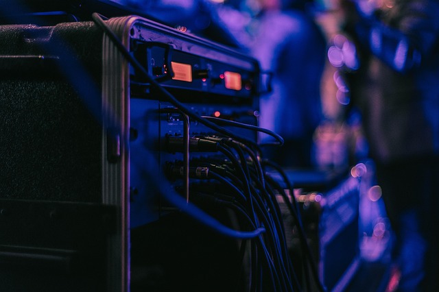 アンプの接続端子にケーブルを丁寧に接続している手元のイメージ