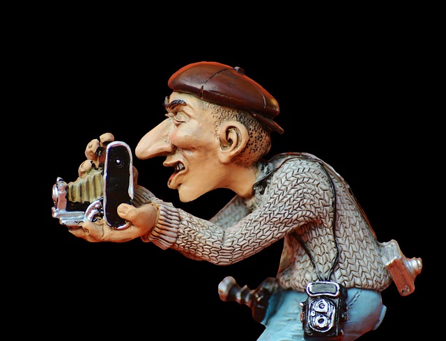 スタイリッシュなコンパクトデジタルカメラを手に持ち、笑顔で撮影する人物