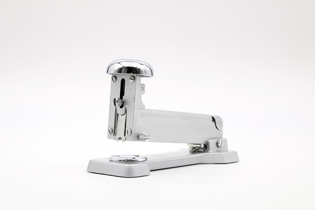 ホッチキスに針を装填している手のイメージ